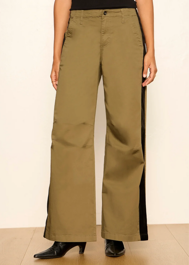 Woman wearing vintage olive pants with black boots.