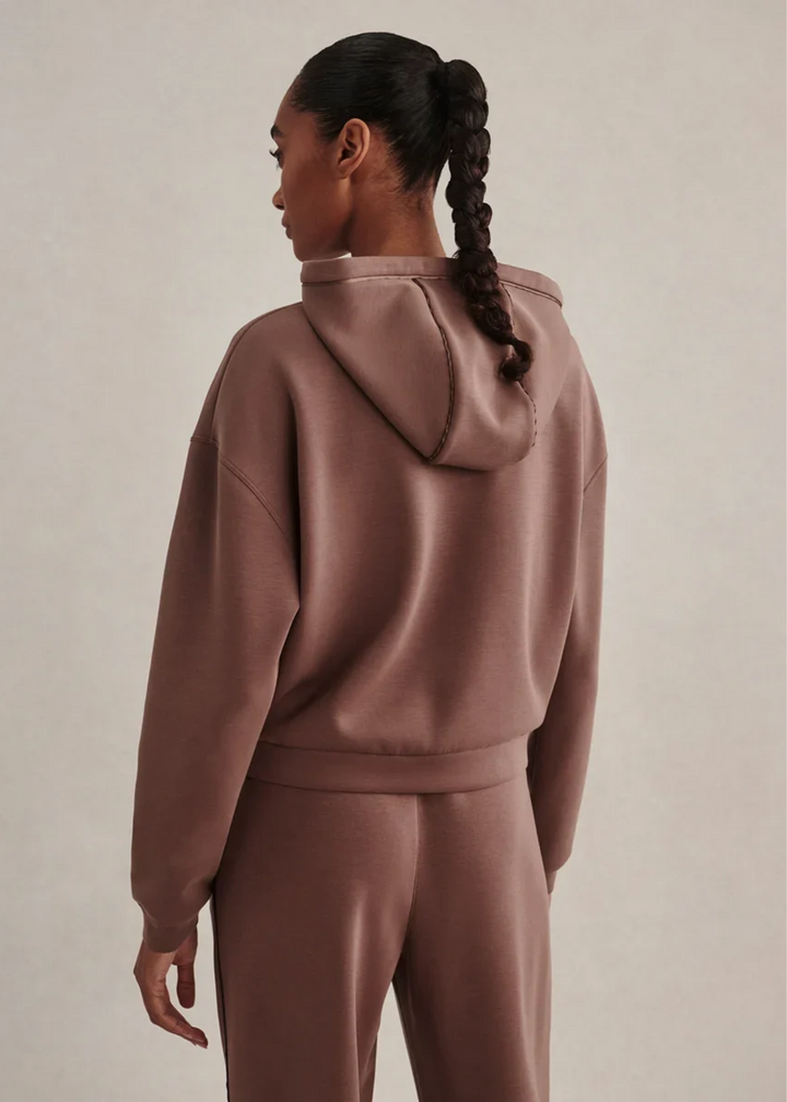 Woman wearing a coffee colored sweat set.