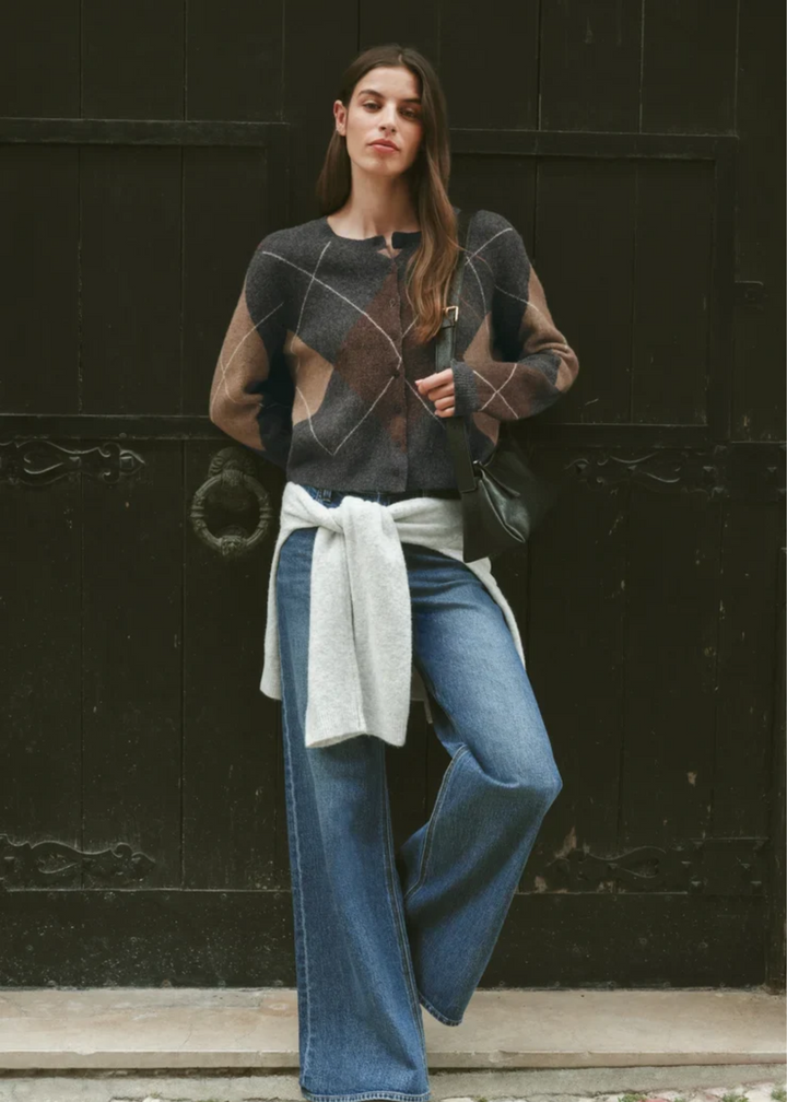 Woman wearing a grey cardigan with argyle pattern.