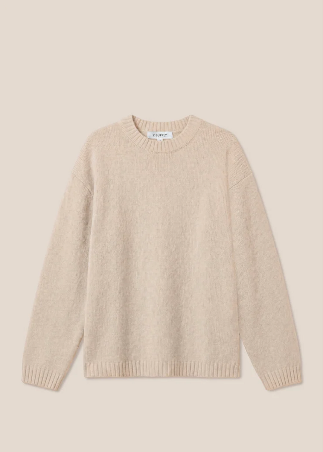 Woman wearing a frosted pearl sweater that is long sleeved.