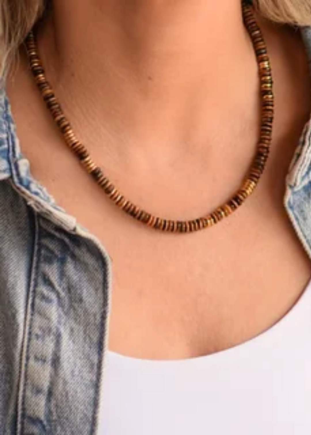 Woman wearing a brown beaded necklace.