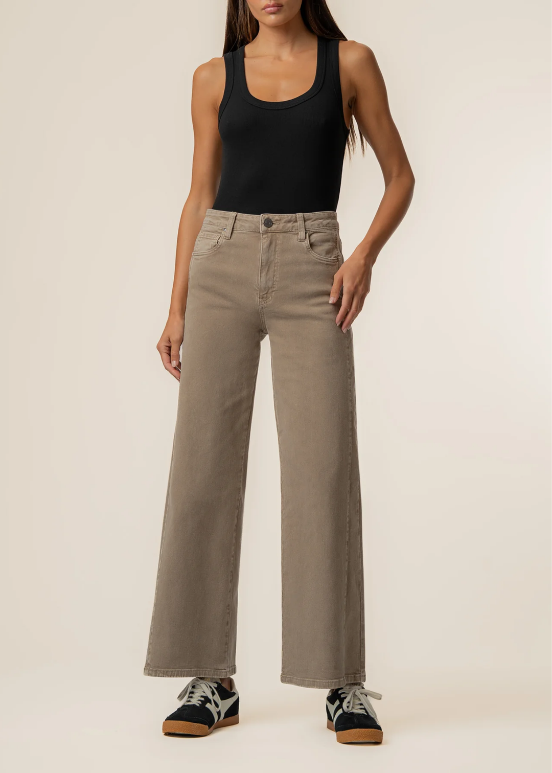 Women facing forward wearing black tank top and milk tea colored wide leg jeans.
