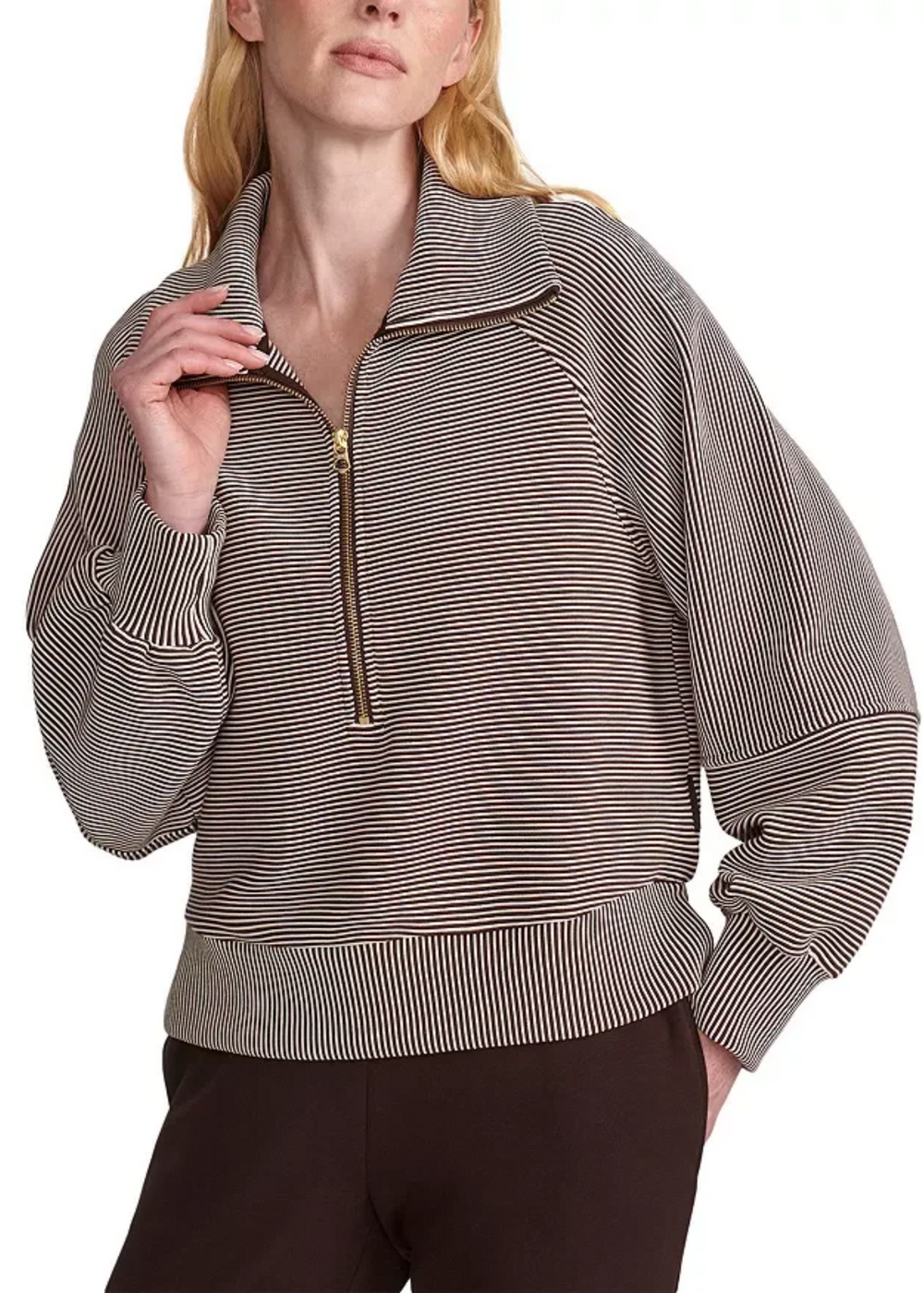 Woman hooding the color of a striped coffee bean/birch half zip. 