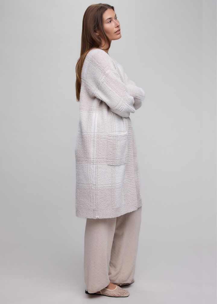 Woman wearing a stone plaid long cardigan over a tan matching set.