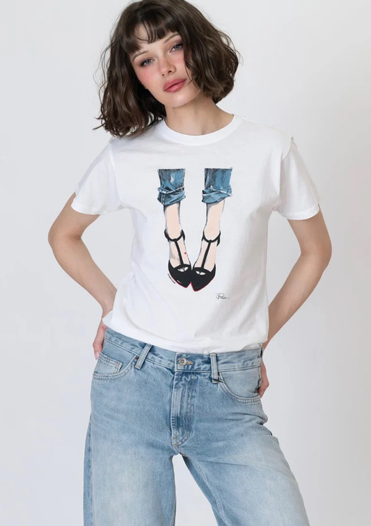 Person wearing a white t-shirt with a graphic design of jeans and high heels, standing against a plain background.