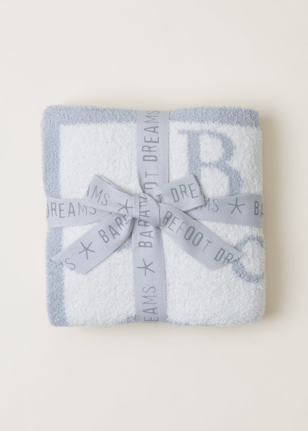 Blue and white ABC pattern blanket folded with a ribbon