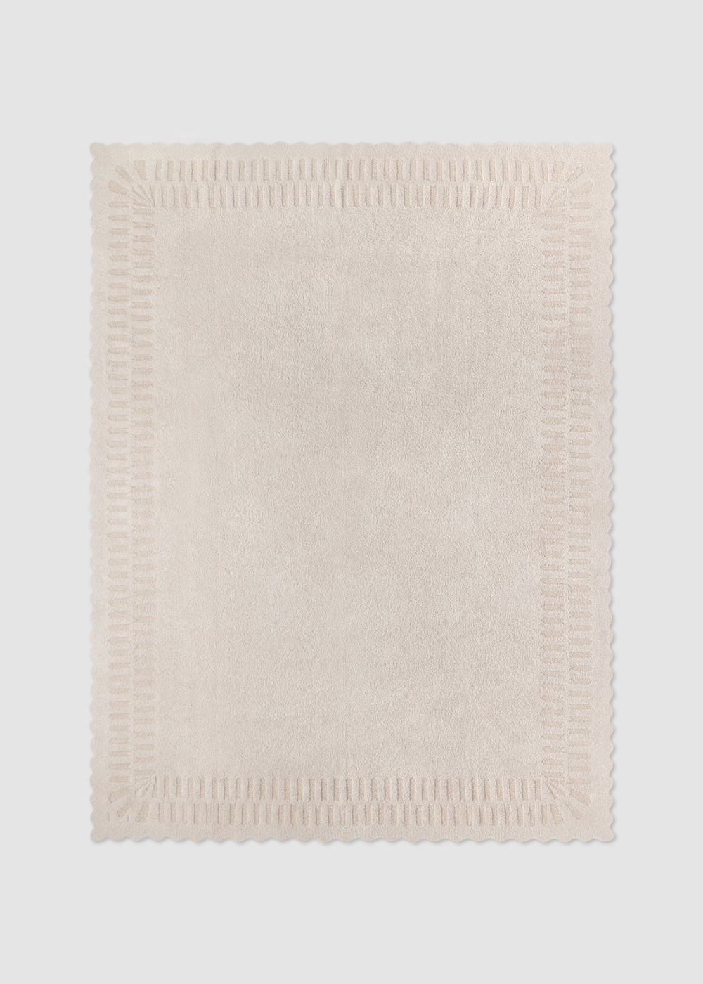 Cream blanket laying on a grey background