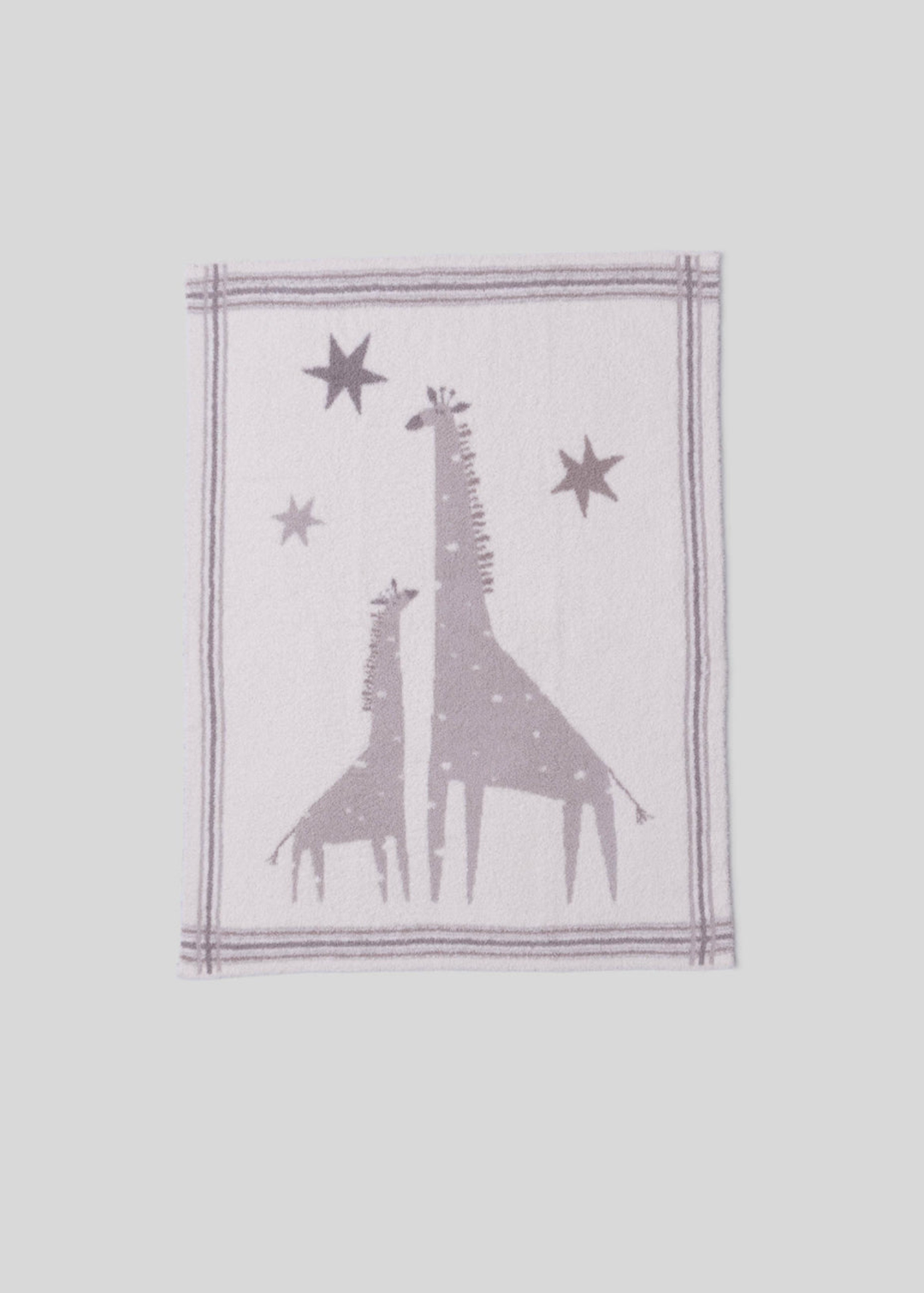 Pink and cream blanket with a giraffe graphic and a striped border on a white background