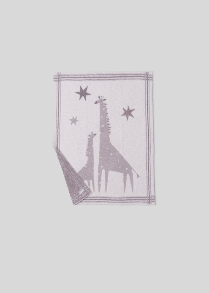 Pink and cream blanket with a giraffe graphic and a striped border with a corner folded on a white background