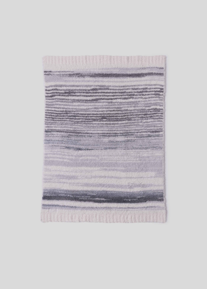 Blue, grey, and cream striped blanket laying on a white background