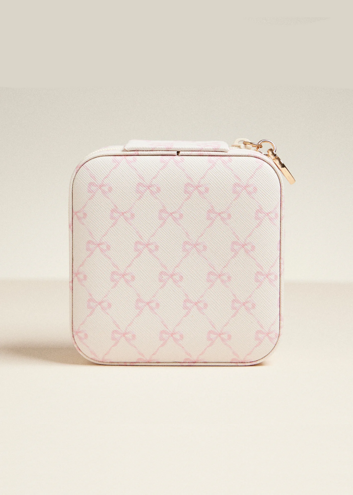 White travel jewelry box with a pink bow pattern on a white background