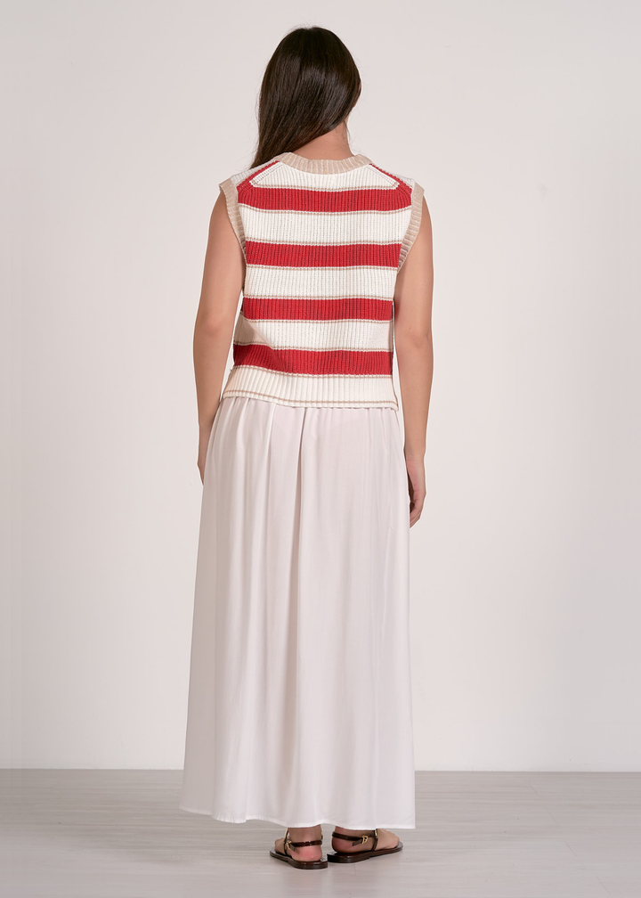 Woman wearing a red and white striped sweater vest and a white skirt