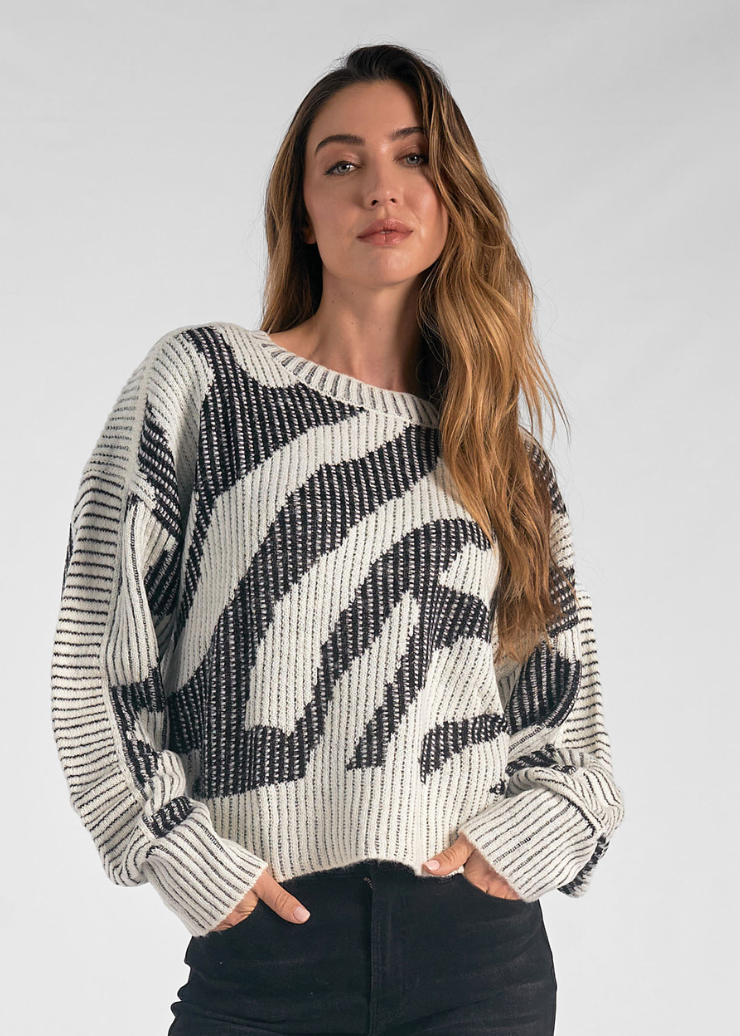 Black and white zebra-patterned sweater with a relaxed fit and ribbed cuffs