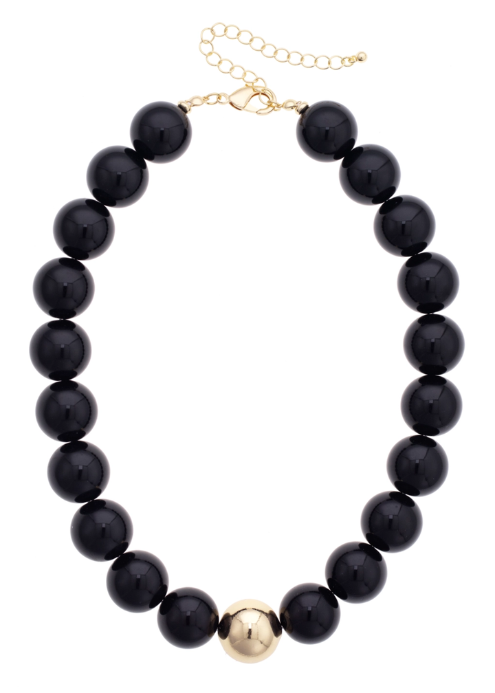 Black beaded necklace with a gold center bead on a white background
