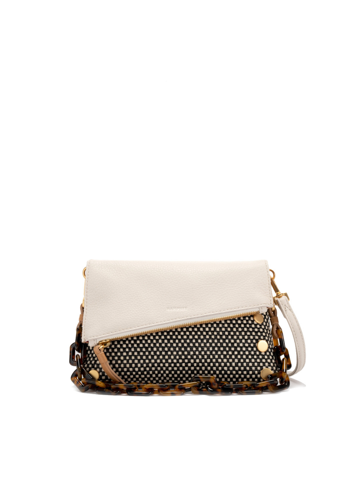 White, tan, and black handbag with gold accents against a white background