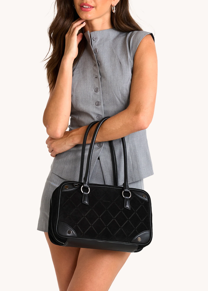 Woman holding a black suede bag