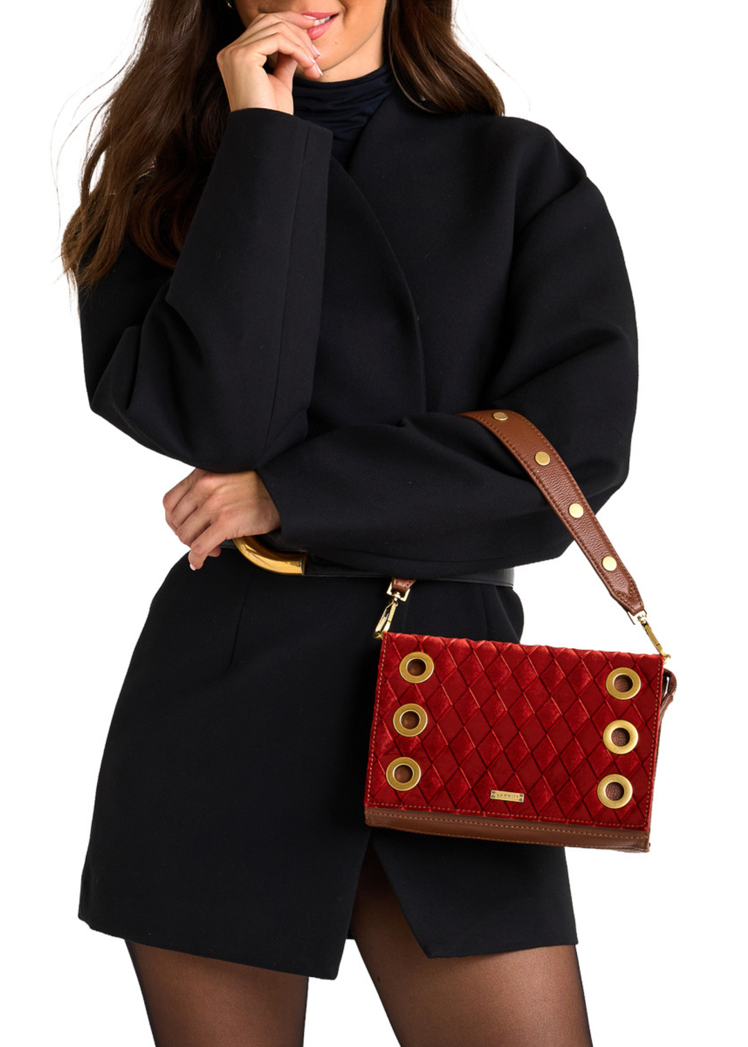 Close up of a woman wearing a black dress and holding a red velvet and brown leather purse with gold accents