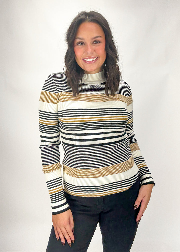 Woman wearing a striped sweater against a plain background