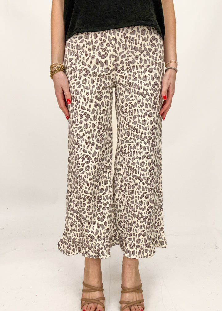 Person wearing leopard print pants on a white background