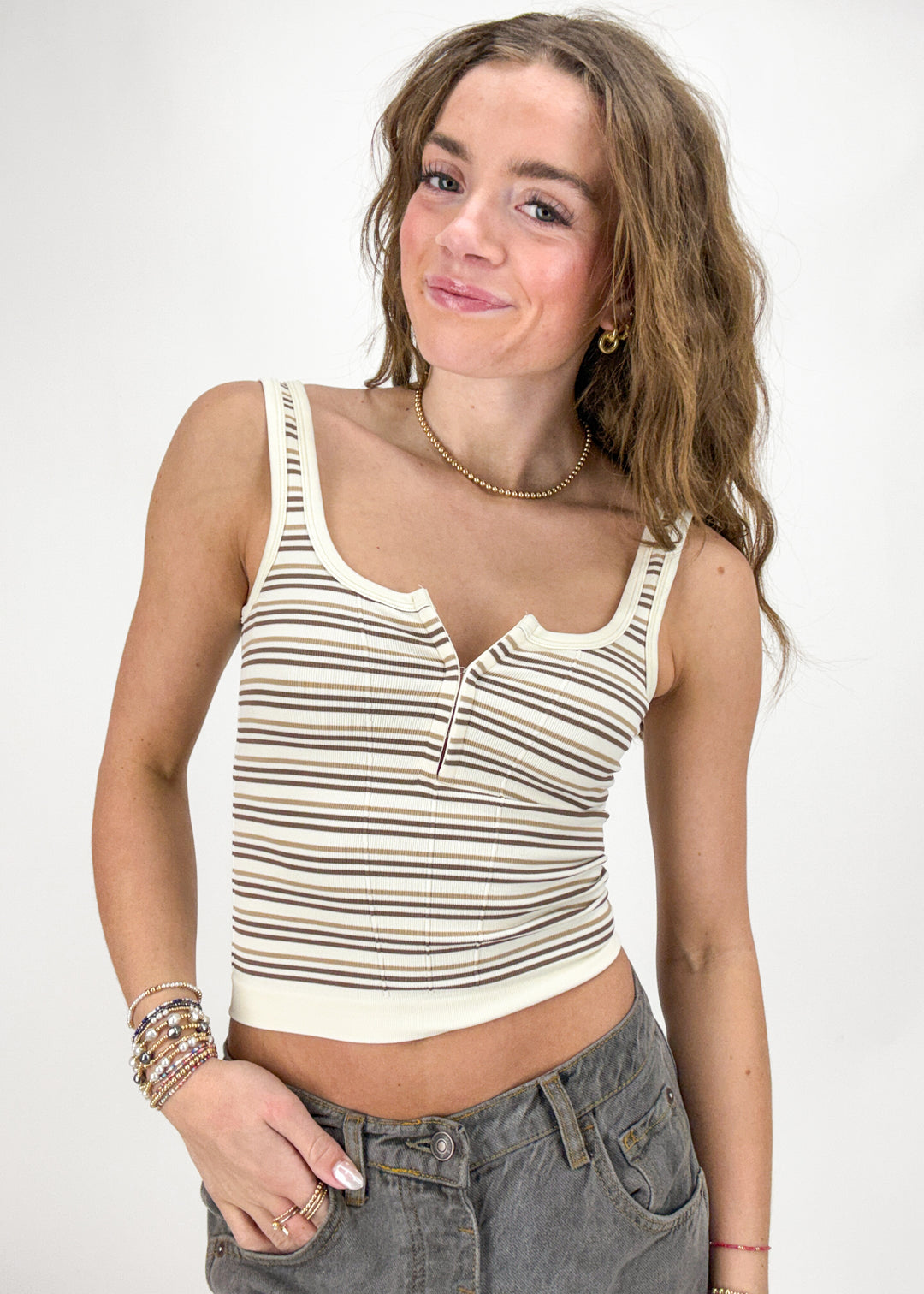 Woman wearing a striped tank top against a plain background