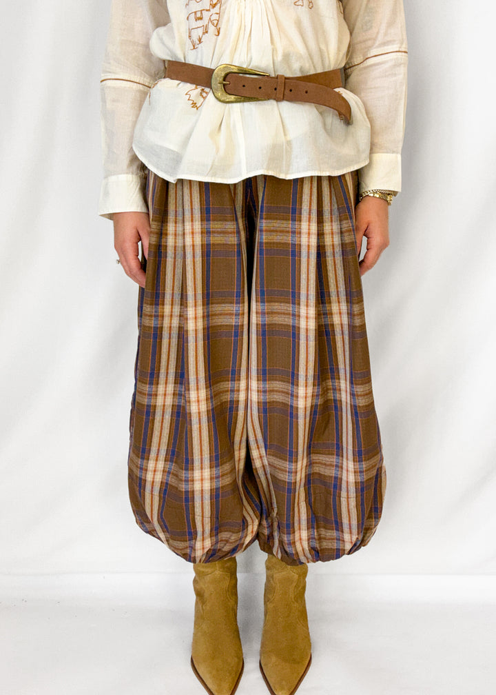 Woman wearing brown plaid balloon style pants