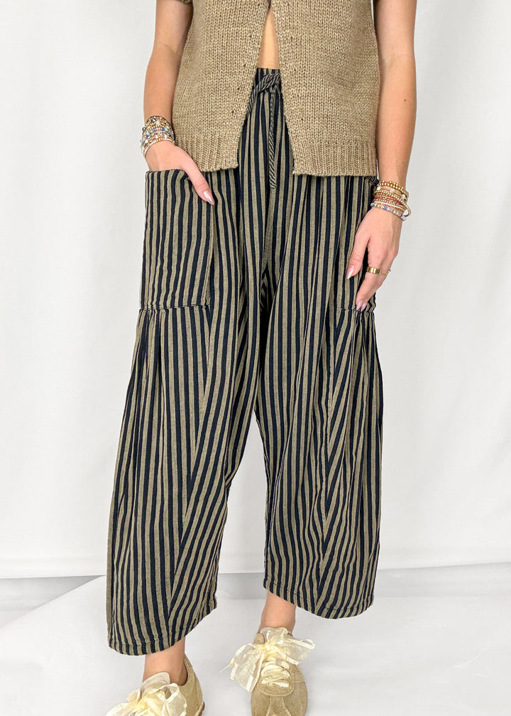 Woman wearing tan and navy striped harlem style pants