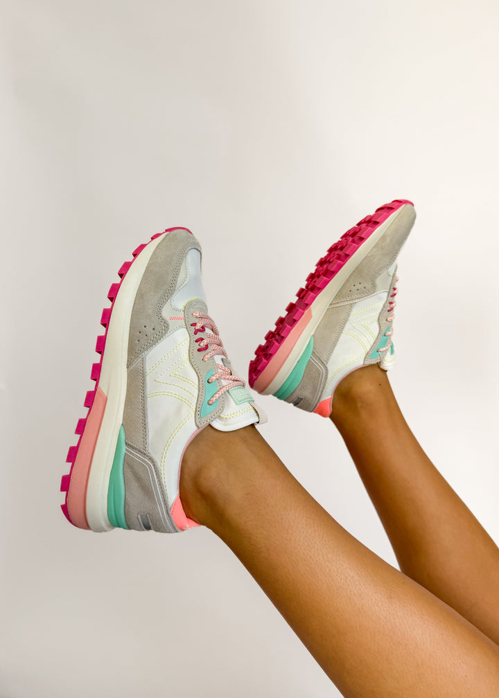 Colorful sneakers with pink soles on a neutral background