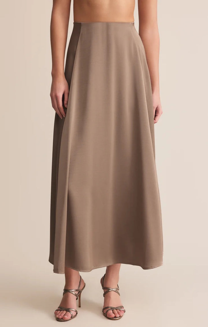 Brown maxi skirt worn by a person on a beige background