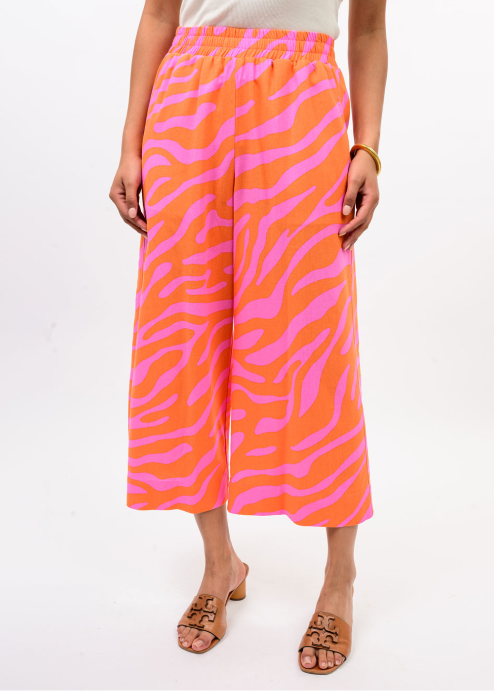 Woman wearing pink and orange zebra print pants with a white top