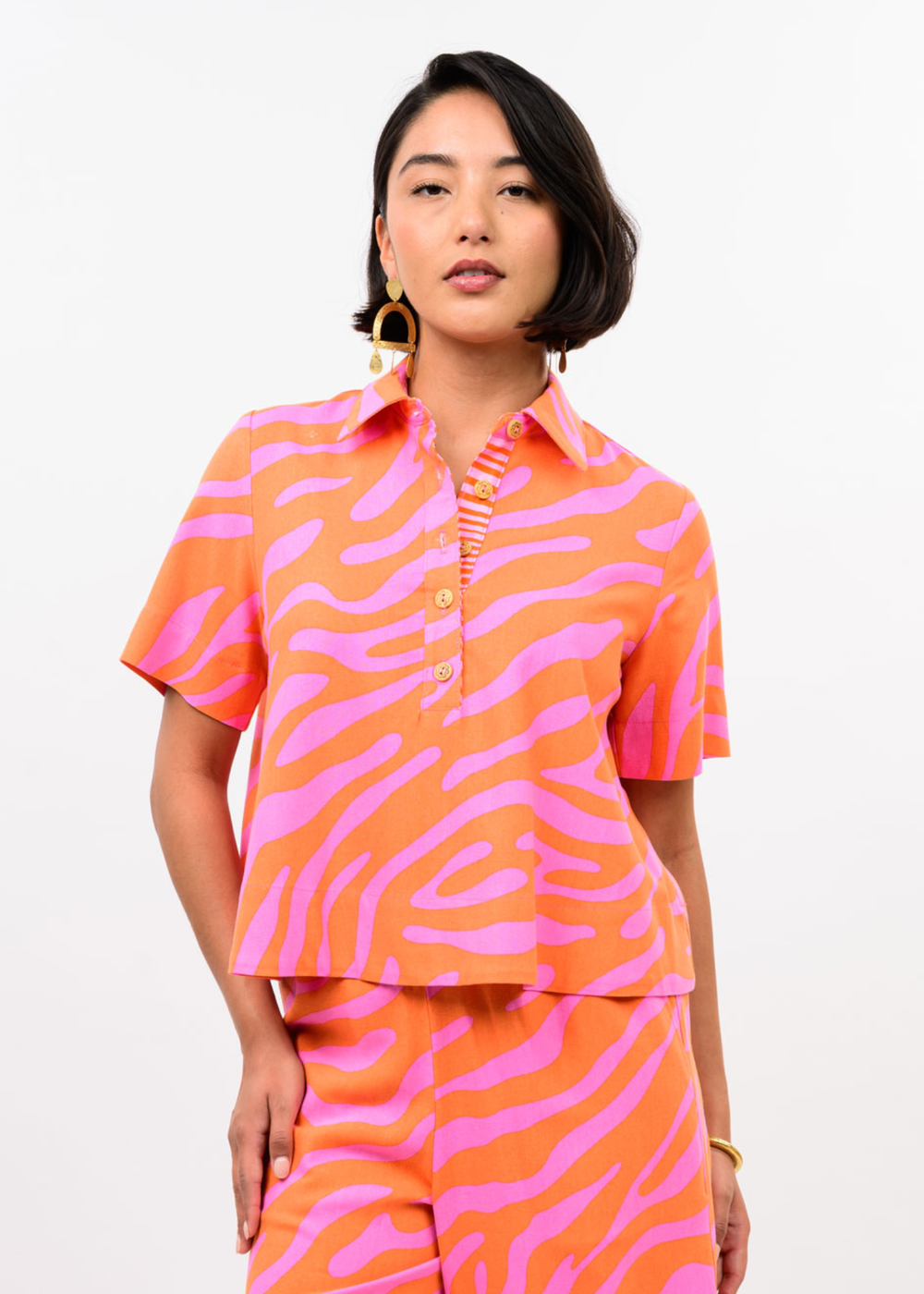 Woman wearing a pink and orange zebra print top with matching pants