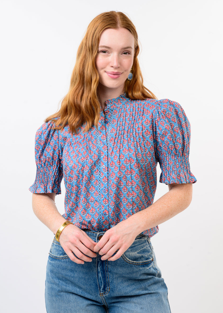 Woman wearing a blue and red floral top with jeans