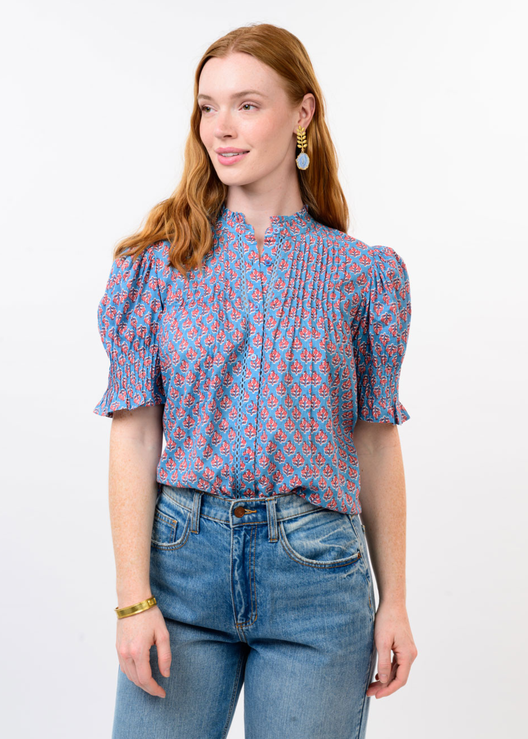 Woman wearing a blue and red floral top with jeans