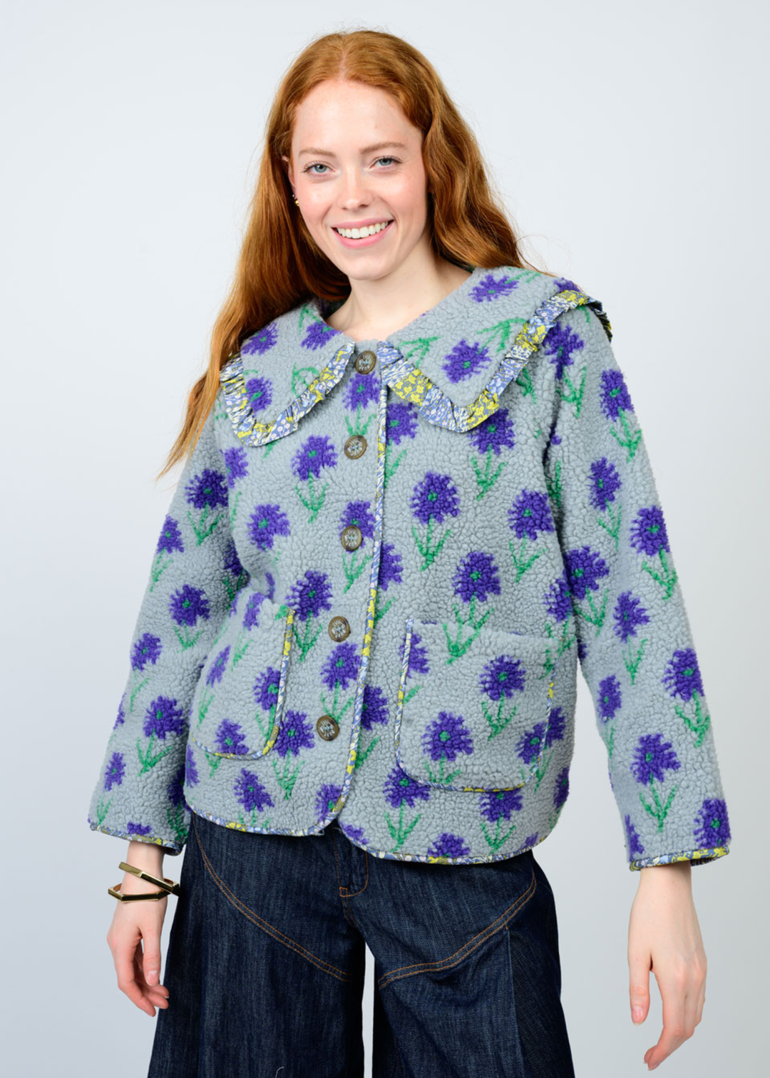 Woman wearing a blue floral jacket against a white background