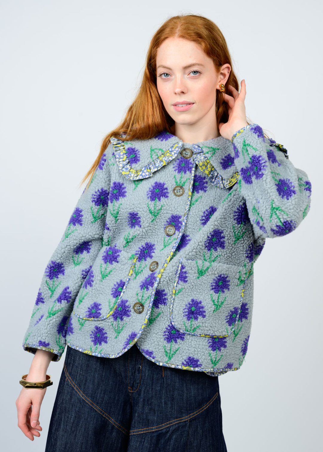 Woman wearing a blue floral jacket against a white background