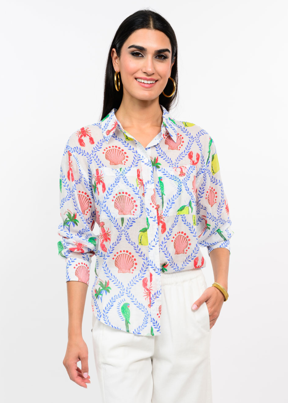 Woman wearing a white button down with a multicolor pattern with white jeans