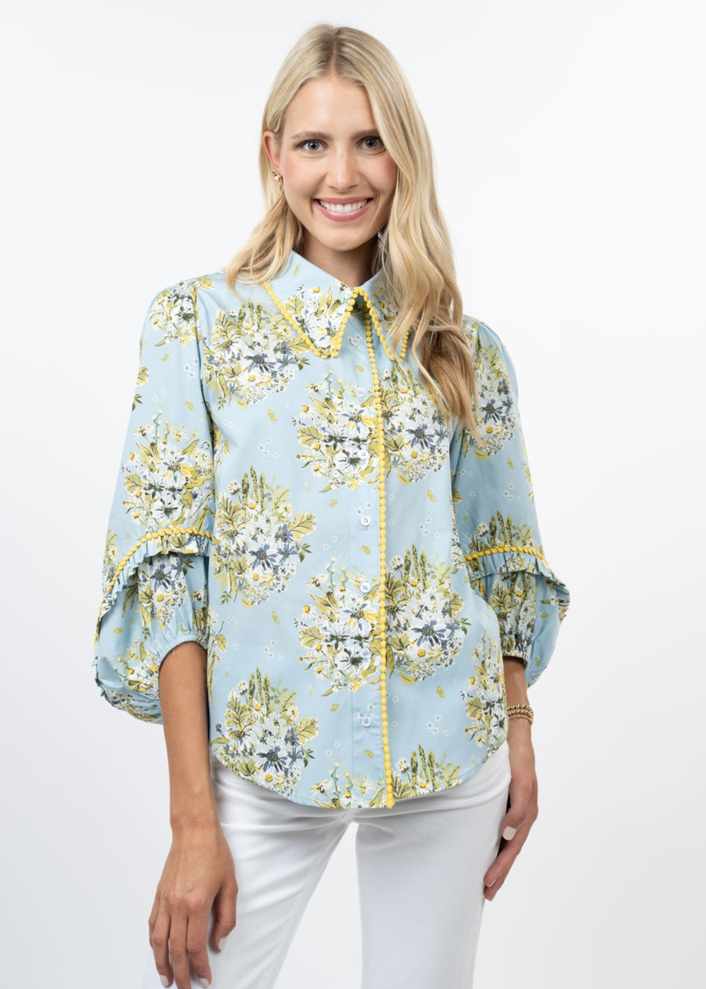 Woman wearing a blue floral top with white jeans