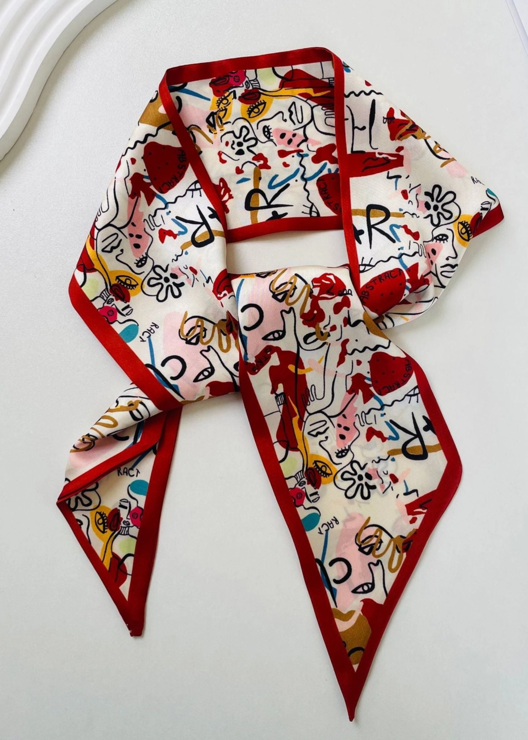 Red and white abstract pattern satin scarf on a white background