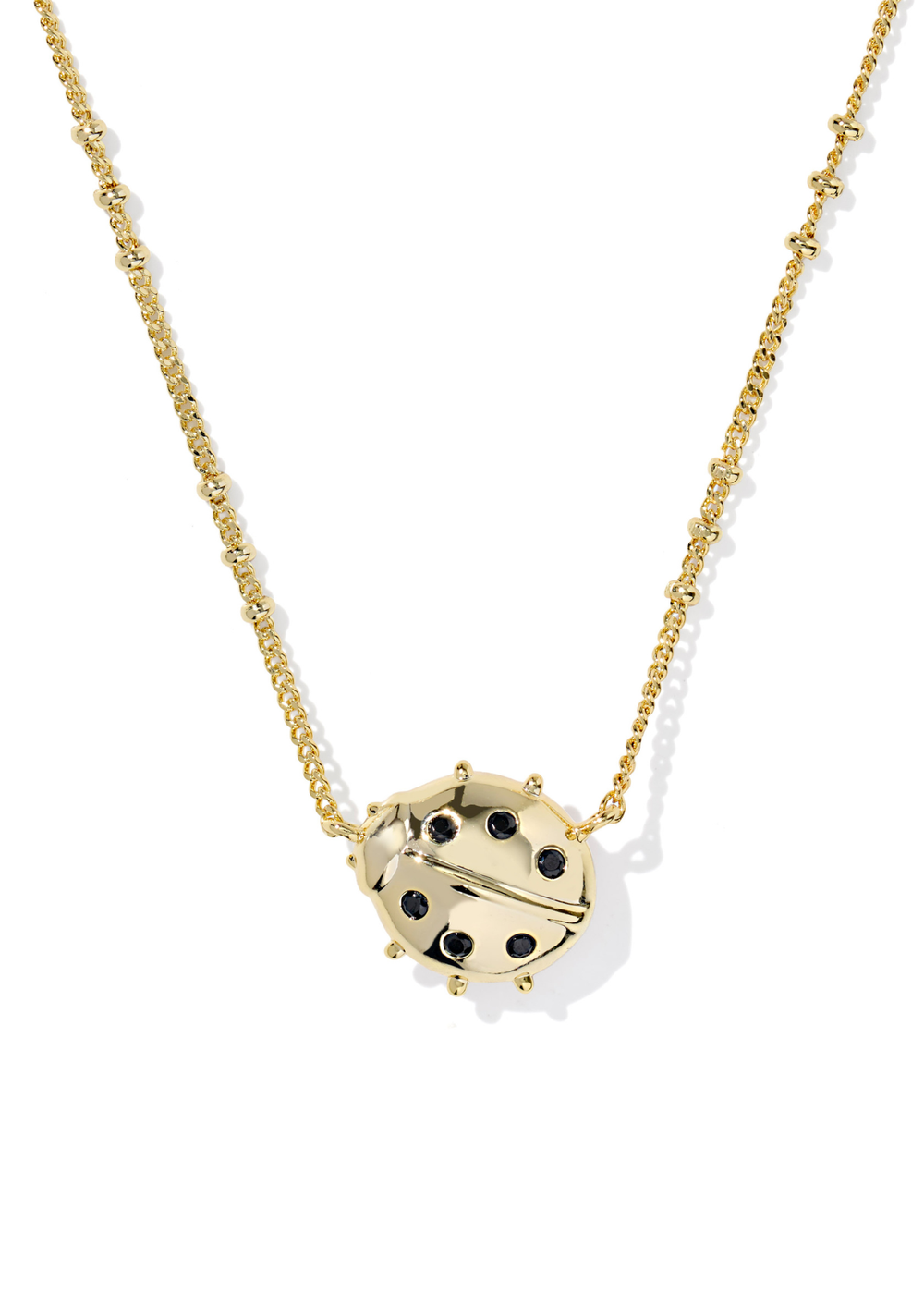 Gold necklace with a gold and black ladybug pendant on a white background