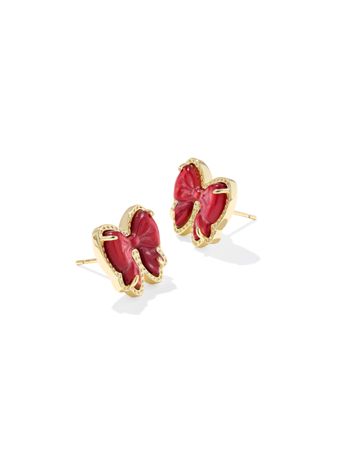 Gold framed red bow shaped stud earrings on a white background