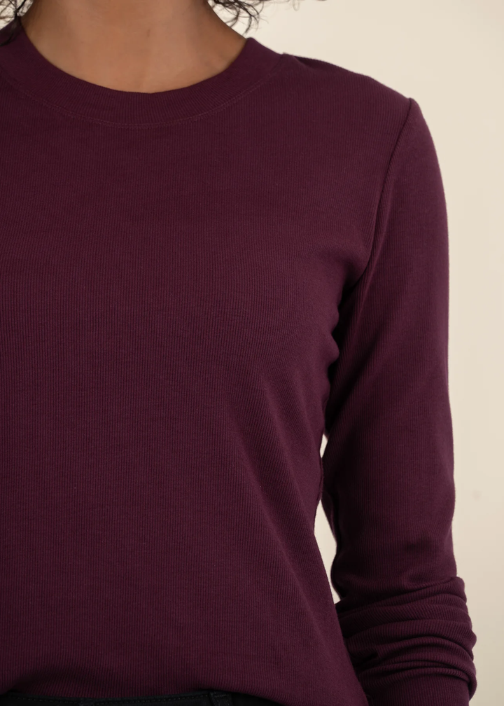 Close up of a woman wearing a maroon long sleeve tee