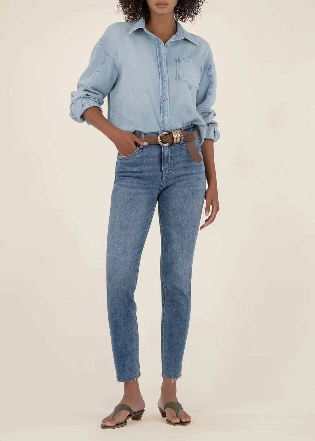 woman wearing medium blue denim skinny jeans paired with light blue chambray top and brown leather belt