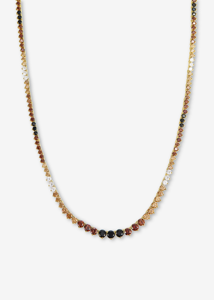 Black, brown, and white tennis necklace laying on a white background