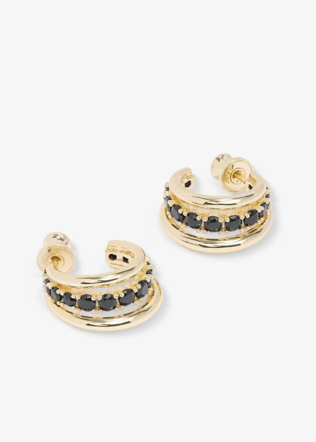A pair of hoop earrings with two smooth gold hoops with a row of black simulated diamonds in the middle