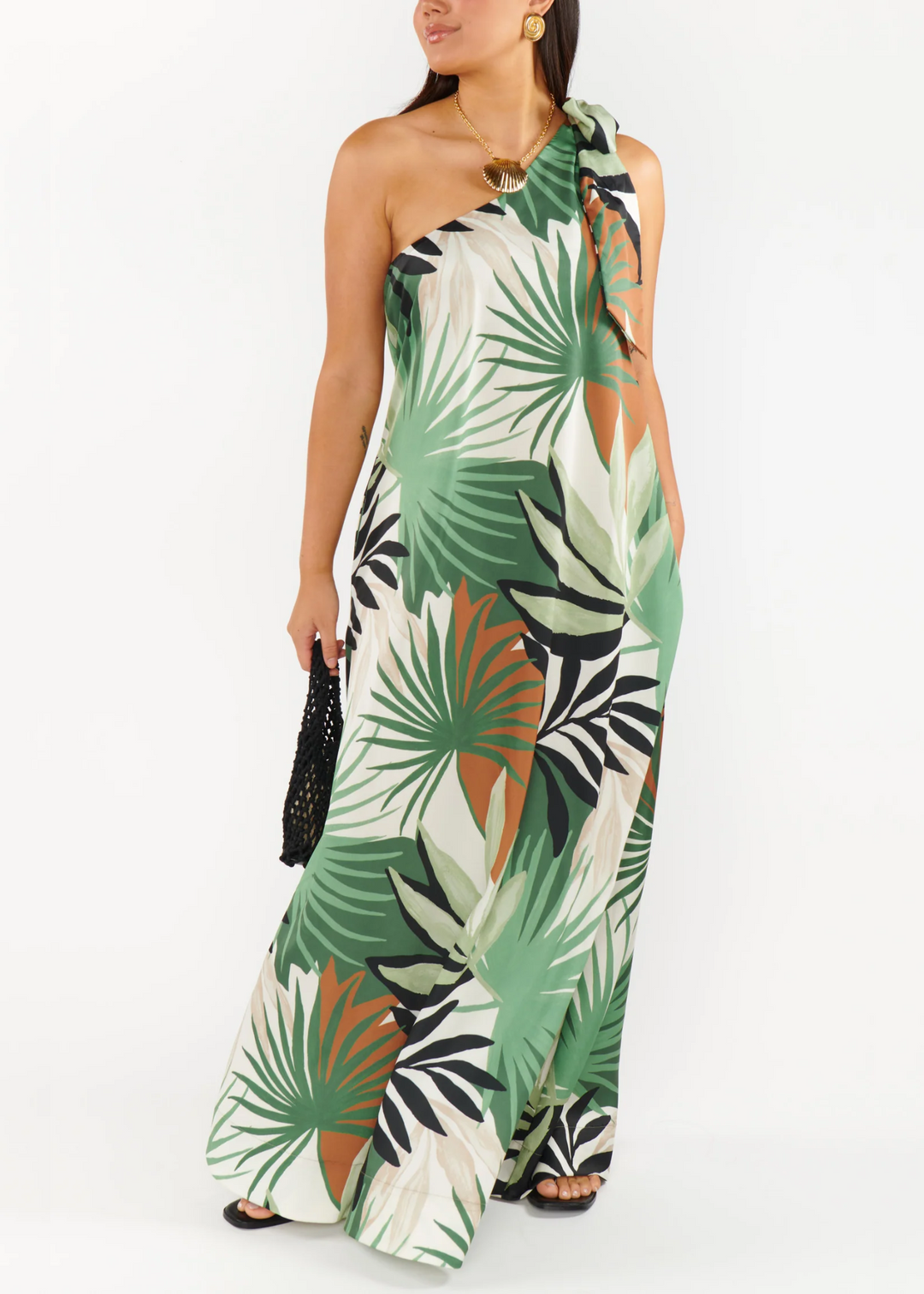 Woman wearing a tropical patterned, one shoulder dress