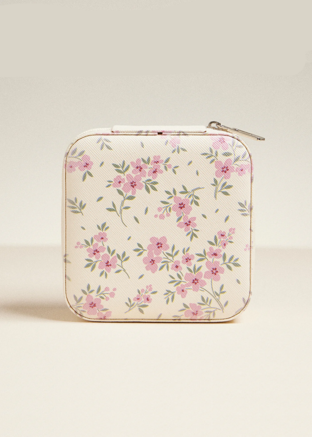 A white travel jewelry box with a pink and green floral design on a light grey background