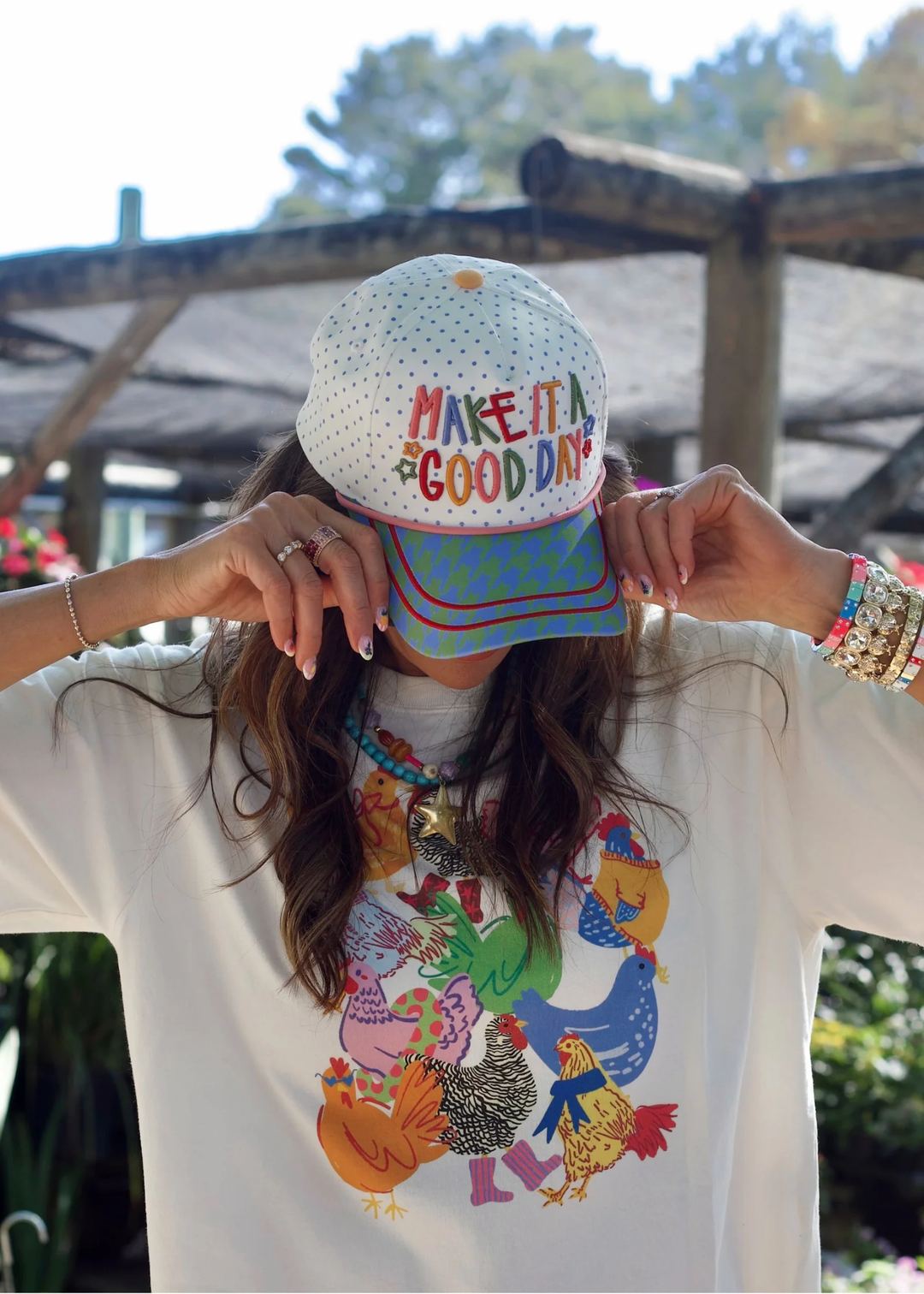 Woman wearing a hat with a "Make It A Good Day" graphic