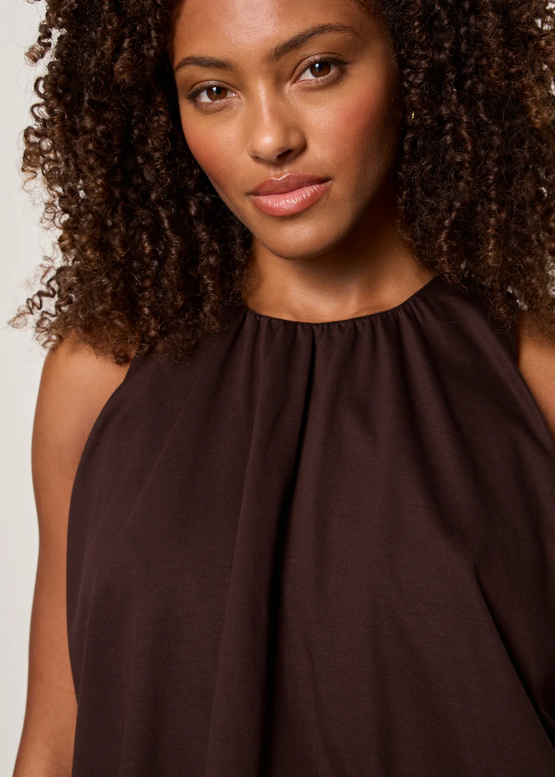 Close up of a woman wearing a brown tank top with matching pants
