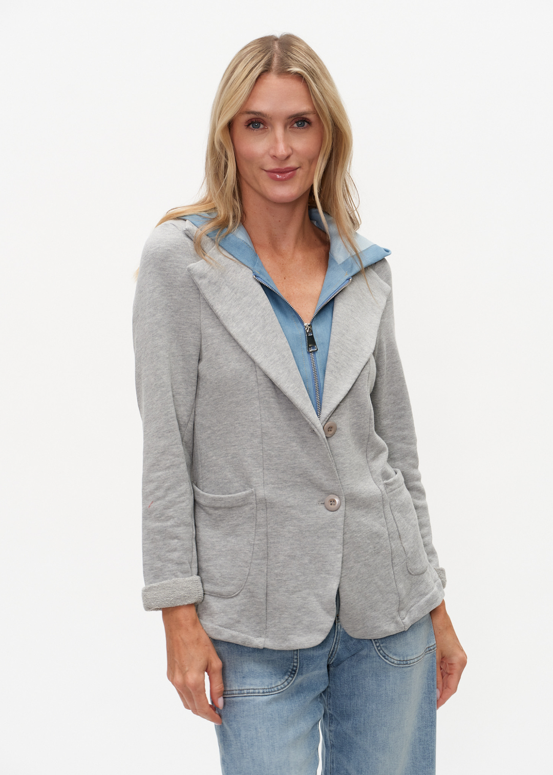 Woman wearing a denim and grey knit hooded blazer with jeans
