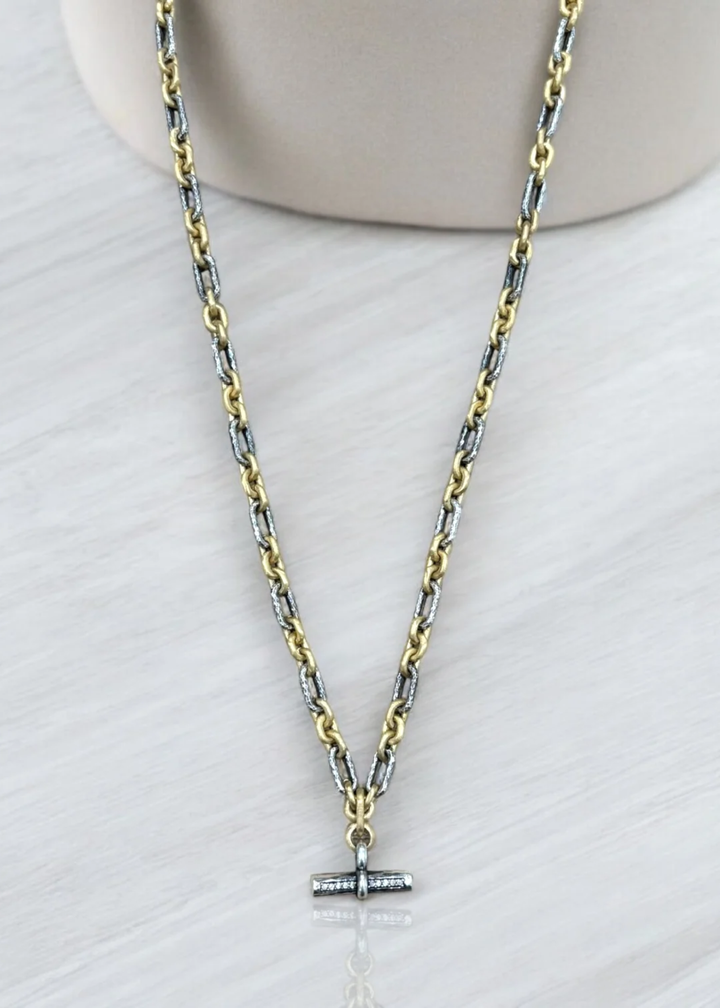 Mixed metal chain necklace with a CZ studded toggle on a white background