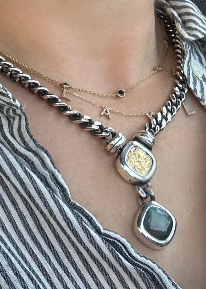 Woman wearing a vintage silver chain necklace with a gold coin and labradorite pendant